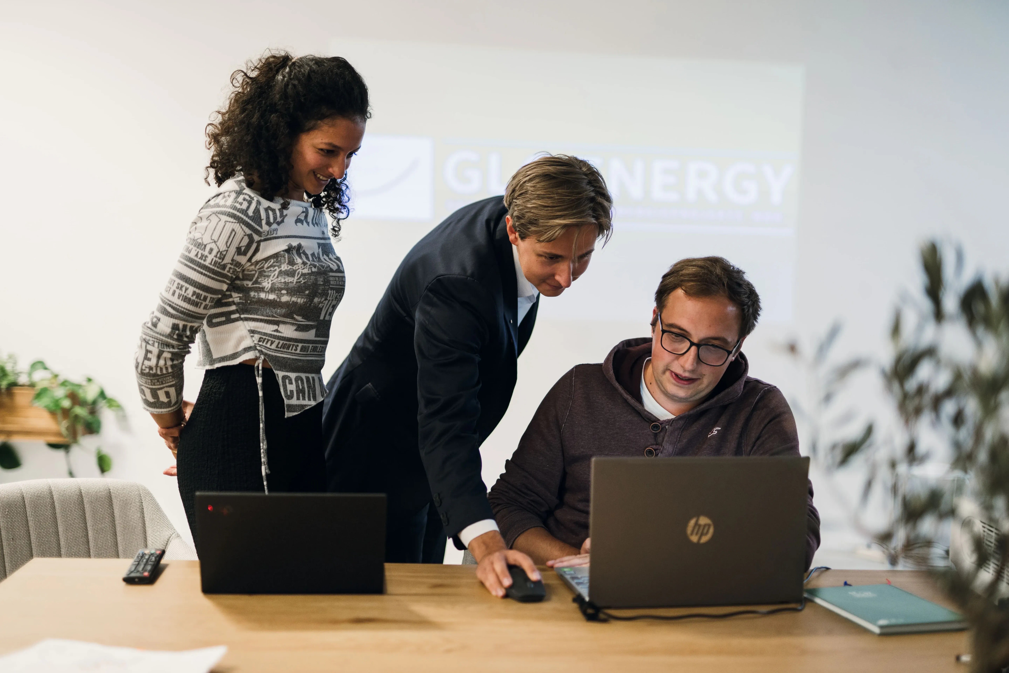 Drei Personen besprechen ein Projekt gemeinsam am Laptop im Büro