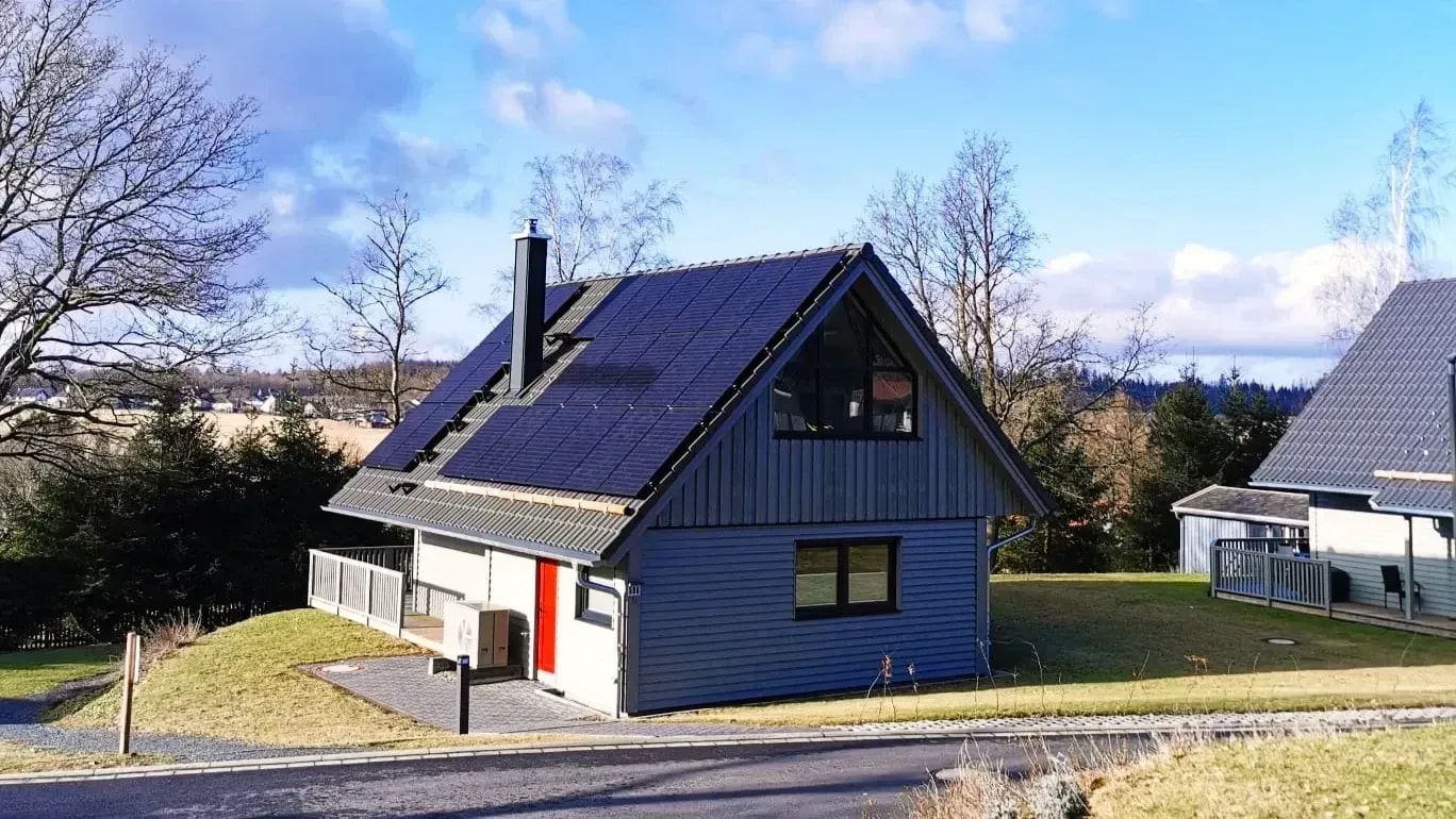 Modernes Ferienhaus mit Solaranlage auf dem Dach in Clausthal-Zellerfeld an einem sonnigen Wintertag